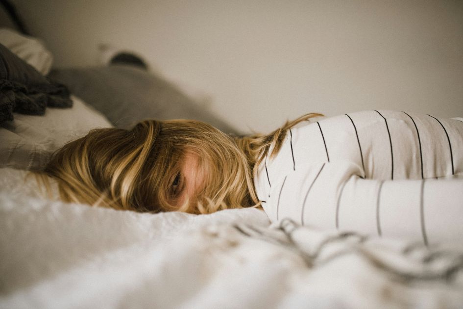 A Tired Girl Lying On Her bed