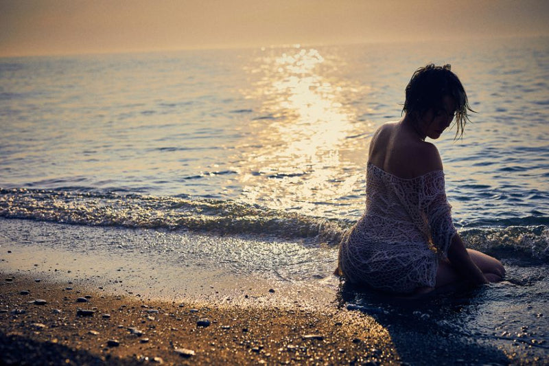 A woman at the beach trying to overcome bedtime anxiety