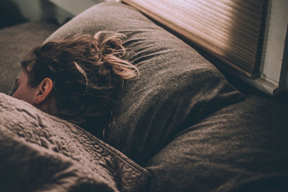 A woman sleeping restfully after using a weighted sleep mask
