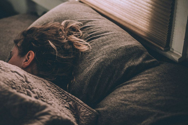 A woman sleeping restfully after using a weighted sleep mask