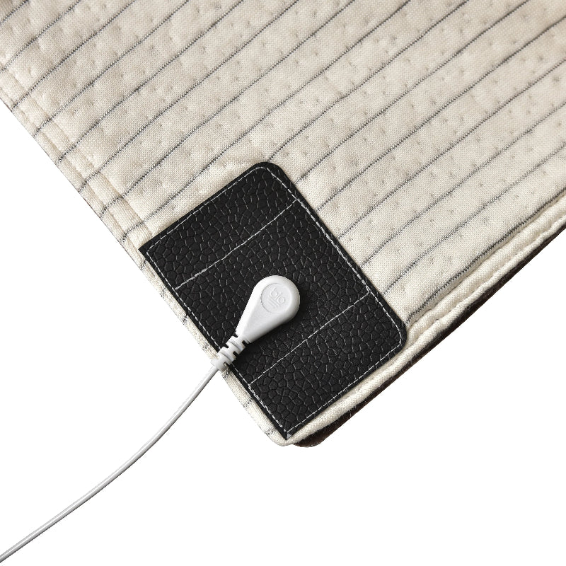 Close-up of the grounding blanket’s connection port and striped conductive surface