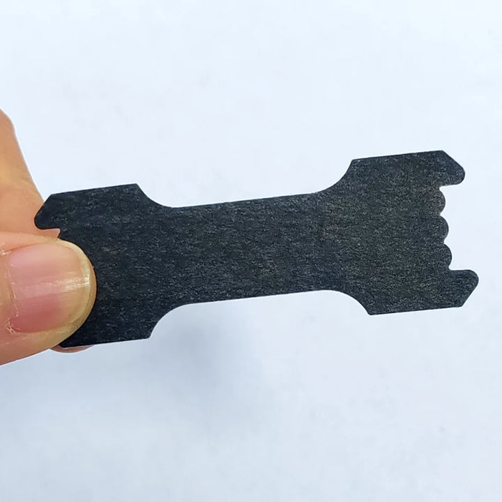 Nasal strip held by a hand on a light blue background - Restora Dream
