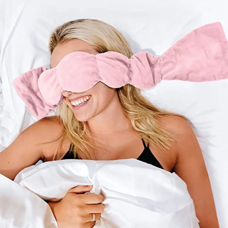 Woman wearing NightCuddle weighted sleep mask pink