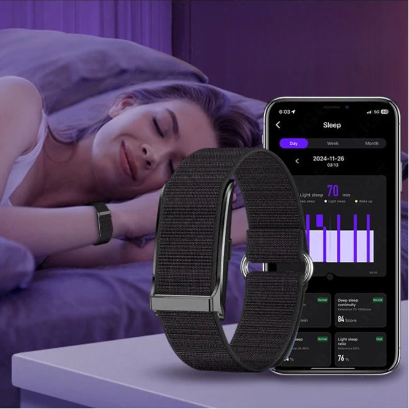 Restora Dream Smart Sleep Band on a table next to a phone displaying sleep tracking app with a woman sleeping in the background.